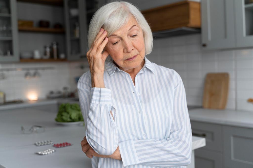 An older woman with her head in her hands, illustrating the emotional toll of dementia and the struggle with memory loss.